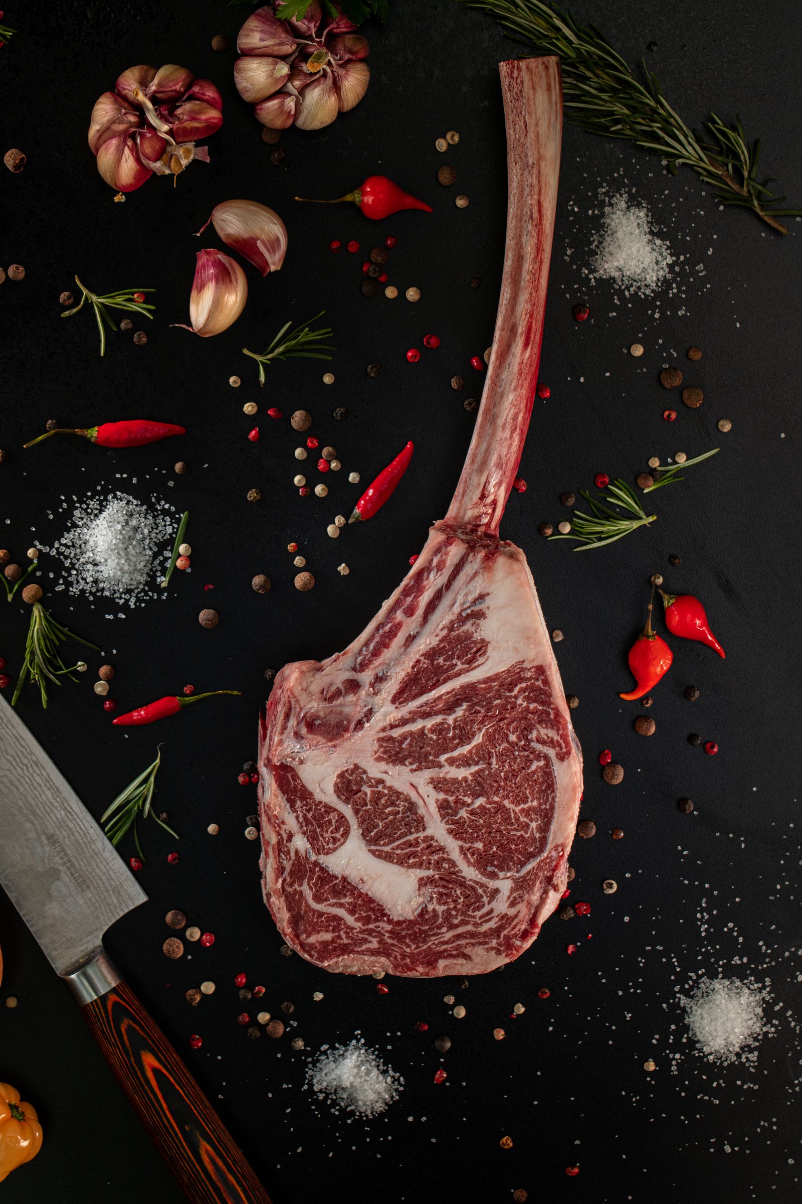 Tomahawk de bœuf cru aux herbes, pièce de bœuf prestigieuse avant cuisson